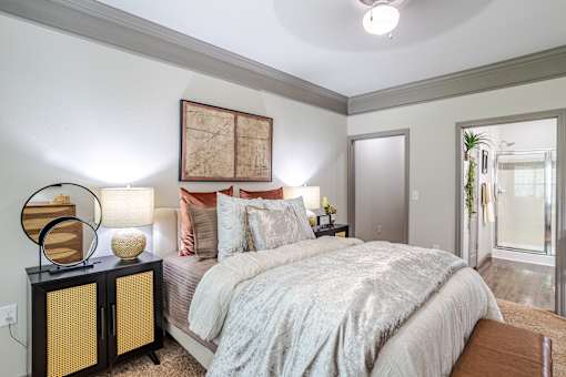 A bedroom with a bed, nightstand, and a painting on the wall at Avenues at Shadow Creek Ranch Apartments, Pearland, 77584