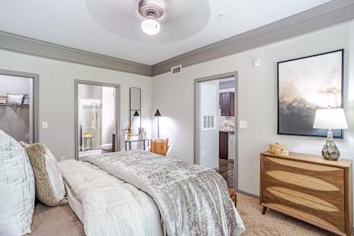 A bedroom with a large bed and a painting on the wall at Avenues at Shadow Creek Ranch Apartments, Pearland