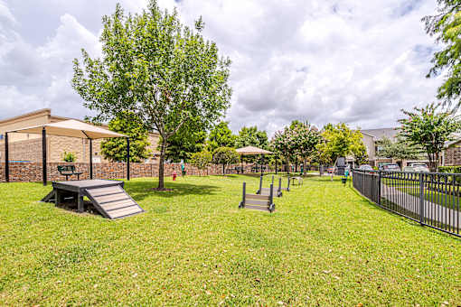 A park with a playground and a building in the background at Avenues at Shadow Creek Ranch Apartments, Pearland, Texas