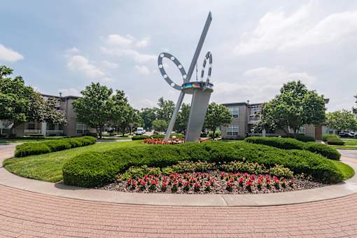 A large sculpture in the shape of a heart is surrounded by a circular garden with red flowers. at CityView, North Kansas City, 64116