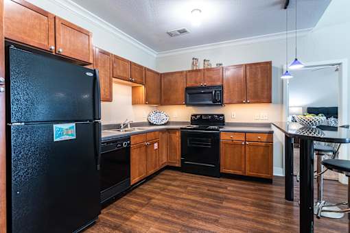 A kitchen with wooden cabinets and black appliances. at CityView, North Kansas City, Missouri