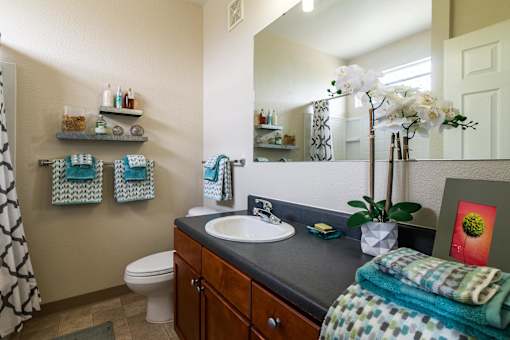 A bathroom with a toilet, sink, and towel rack. at CityView, North Kansas City, Missouri