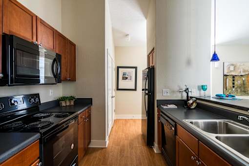 A kitchen with black appliances and wooden cabinets. at CityView, North Kansas City, 64116