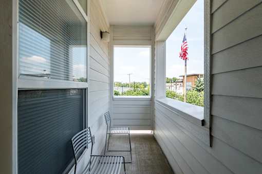 A white porch with a bench and a chair. at CityView, Missouri, 64116