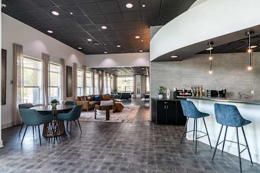 A modern kitchen and dining area with dark flooring and a curved ceiling. at CityView, North Kansas City, MO