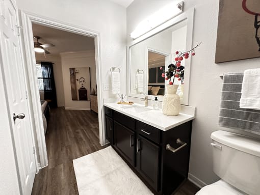 a bathroom with a large mirror and a sink at Grand Villas Apartments, Katy