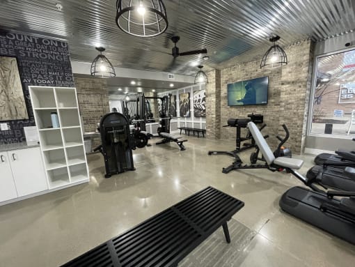 the gym has a lot of equipment and a tv