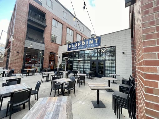 an outdoor patio with tables and chairs outside of a restaurant at The MK, Indianapolis, 46220