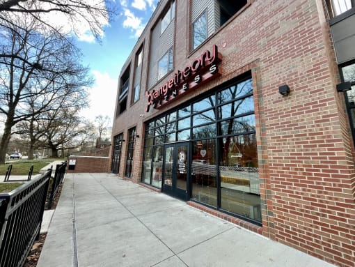 a brick building with a sign in the window and a sidewalk at The MK, Indianapolis, 46220