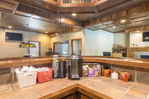 Community coffee bar with wooden cabinetry at London House Apartments, Lenexa, KS