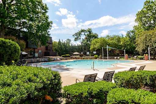 Resort style pool with volleyball net and lounge chairs at London House Apartments, Lenexa, KS 66215