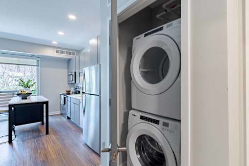 A white washing machine is in a cabinet in a modern kitchen.
