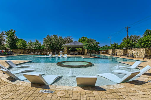 the pool is heated and has a gazebo and chairs around it at Discovery at Craig Ranch, Texas, 75070