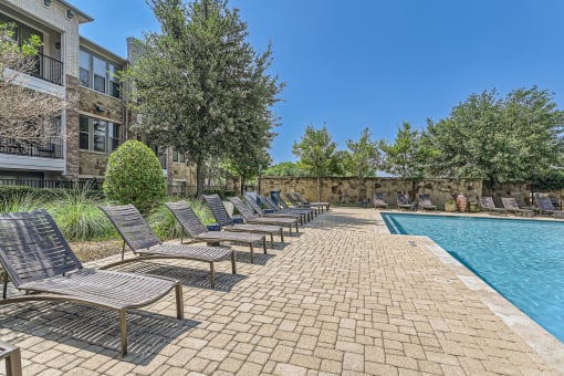 a swimming pool with chaise lounge chairs next to a building at Discovery at Craig Ranch, McKinney, Texas