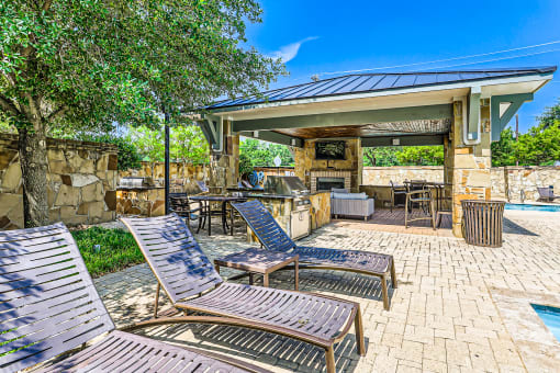 a covered patio with chairs and a grill next to a pool at Discovery at Craig Ranch, McKinney, TX