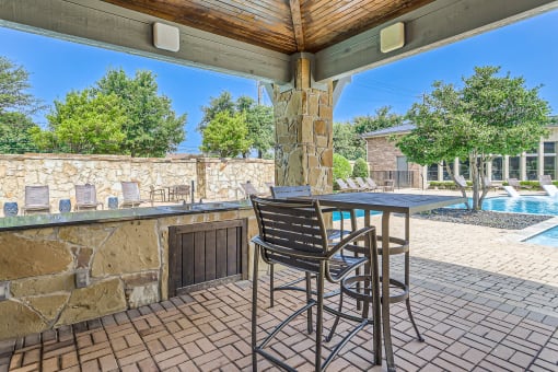 a patio with a table and chairs and a pool at Discovery at Craig Ranch, McKinney, TX