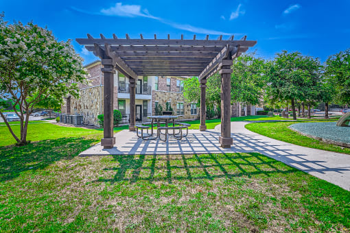 a patio with a picnic table and a pergola at Discovery at Craig Ranch, McKinney, Texas