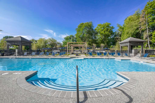 a swimming pool with chairs and gazebos at the resort at governors island  at Butternut Ridge, North Olmsted, Ohio