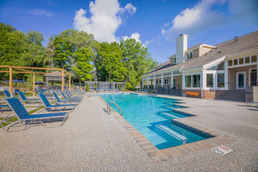 a resort style pool with blue chairs and a building with trees  at Butternut Ridge, Ohio