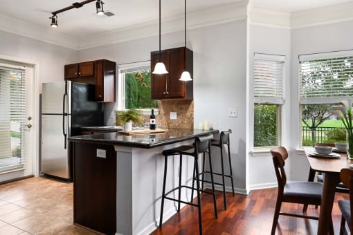 a kitchen with a bar and a table with stools at Sovereign at Overland Park, Overland Park, KS 66213