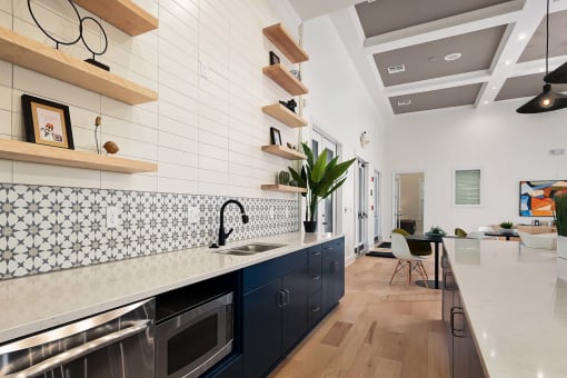 a kitchen with a long counter top and a sink at Sovereign at Overland Park, Overland Park