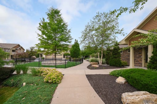 the walkway through the neighborhood is lined with trees and bushes at Sovereign at Overland Park, Overland Park, 66213