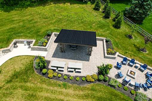 A patio with a fire pit and chairs is surrounded by a grassy area. at Overland Park, Pickerington, OH