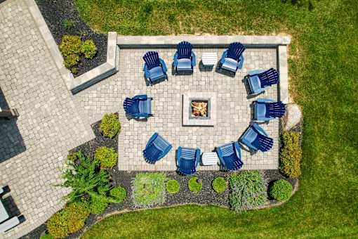 A fire pit surrounded by blue chairs in a garden. at Overland Park, Pickerington, Ohio