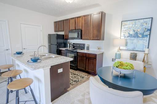 A kitchen with a black refrigerator, white countertops, and wooden cabinets. at Overland Park, Pickerington, OH