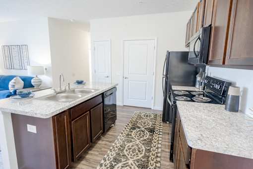 A kitchen with a black refrigerator and a white counter top. at Overland Park, Pickerington, 43147
