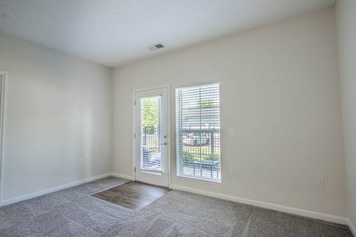 A room with a carpeted floor and a sliding glass door. at Overland Park, Pickerington, 43147