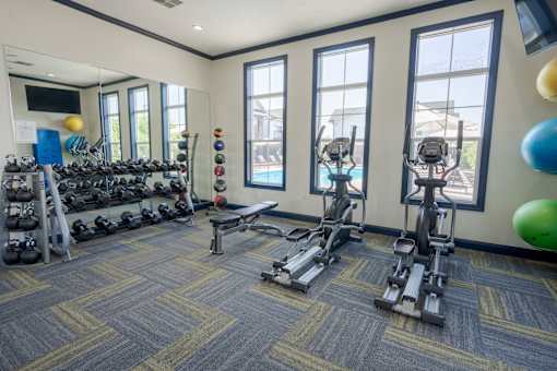 A gym with a variety of equipment including weights and exercise machines. at Overland Park, Pickerington, 43147