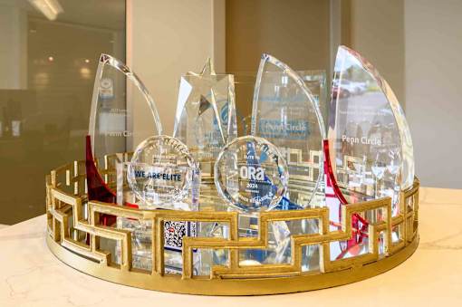 A glass trophy with a red ribbon is placed on a gold base. at Penn Circle, Carmel