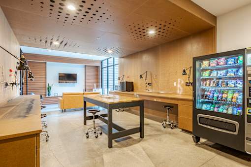 A modern kitchen with a wooden table and a vending machine. at Pinnex, Indianapolis, IN, 46203