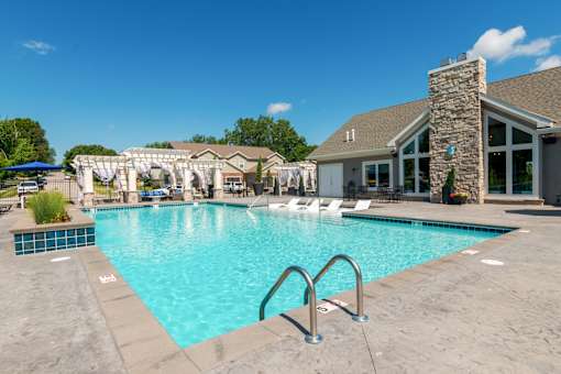 A large swimming pool with a stone building in the background.