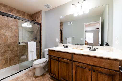 A bathroom with a toilet, sink, and mirror.