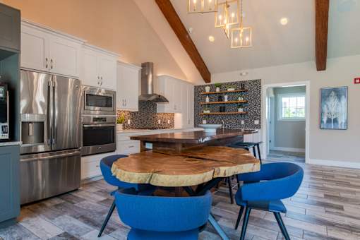 A modern kitchen with a blue chair and a wooden table.