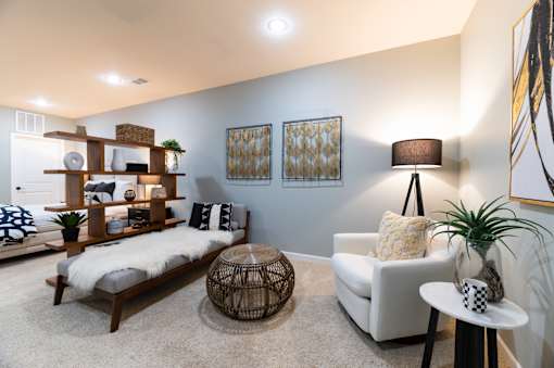 A living room with a white couch, a wooden bench, and a rug.