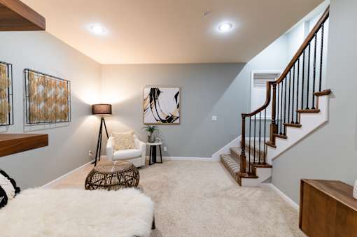 A living room with a white chair and a white rug.
