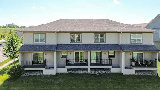 A house with a brown roof and a white front porch.