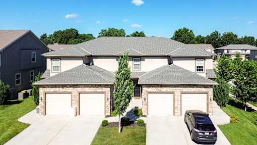 A house with a stone pillar and two garages.