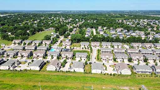 A bird's eye view of a residential area with houses and greenery.