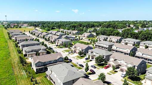 A suburban neighborhood with rows of houses and cars parked in driveways.