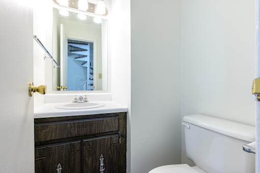 A white sink is in front of a mirror in a bathroom at Spring Creek Townhomes Apartments, Springfield, IL