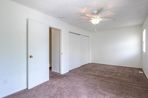 A room with a ceiling fan and carpeted floor at Spring Creek Townhomes Apartments, Illinois