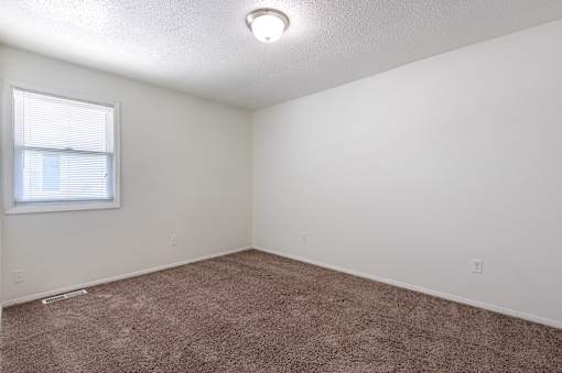 A room with a window and carpeted floor at Spring Creek Townhomes Apartments, Springfield, IL
