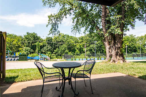 A table and two chairs are set up on a patio.