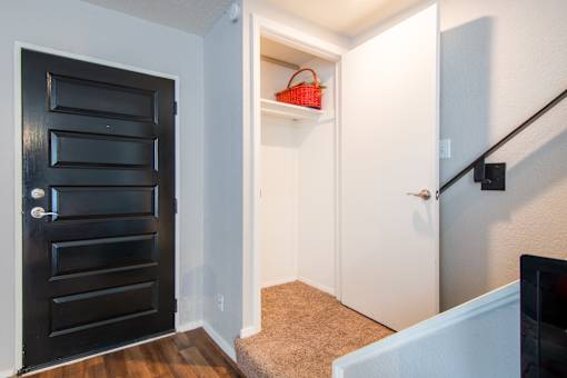 A black door with a white door next to a staircase.