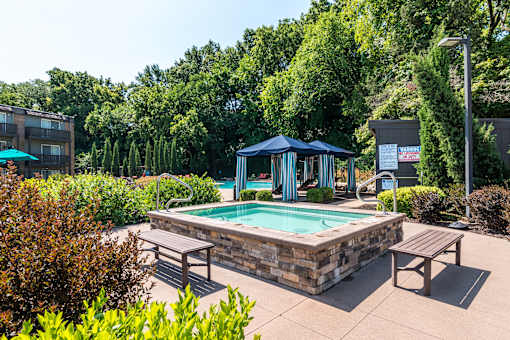 A pool area with a blue canopy and benches.