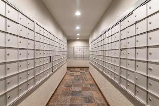 A long hallway with a row of mailboxes on each side.